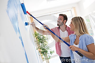 Young smiling couple painting walls Stock Photo