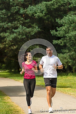 Young smiling couple running in park Stock Photo