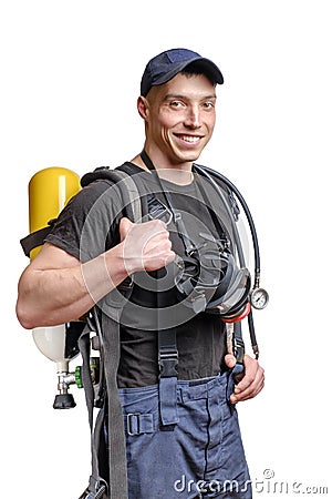 Young smiling firefighter with a mask and an air pack on his back in black t-shirt Stock Photo