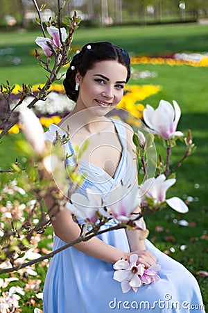 Young smiling girl in evening dress with magnolia Stock Photo