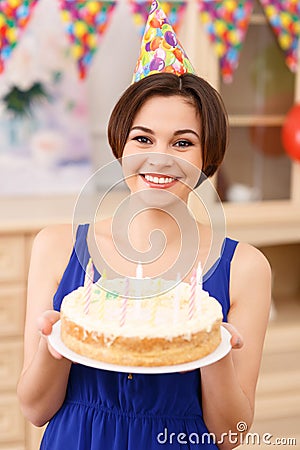 Young smiling girl is holding her birthday cake Stock Photo