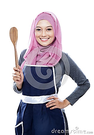 Young smiling housewife holding a wooden spatula Stock Photo