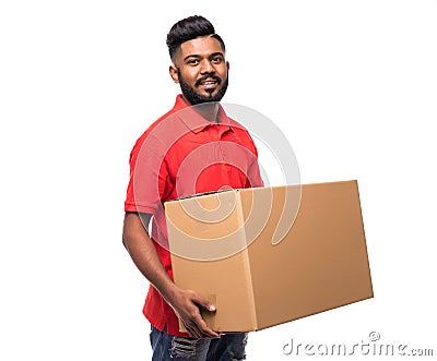 Young smiling indian logistic delivery man in red uniform holding the box on white background Stock Photo