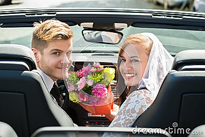 Just Married Couple With Bouquet In The Car Stock Photo