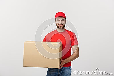 Young smiling logistic delivery man in red uniform holding the box on white background Stock Photo