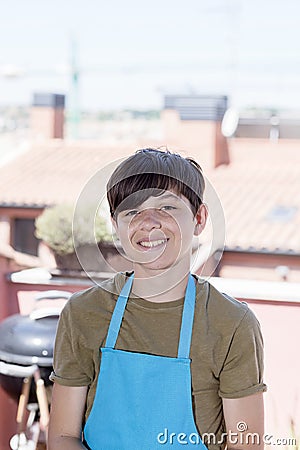 Young smiling teenager standing at terrace wearing a gardener apron Stock Photo