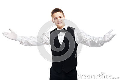 Young smiling waiter opens his arms in welcome Stock Photo