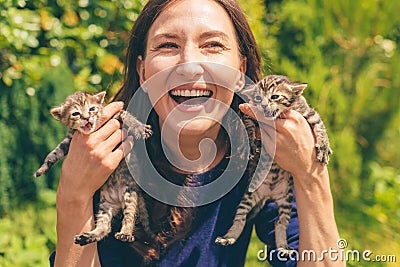 Young smiling woman holding two little kittens in her hands Stock Photo