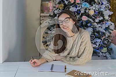 Young smiling woman next to the tree looking at the camera and smiling Stock Photo