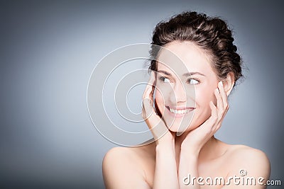 Young smiling woman touching her healthy, fresh face. Stock Photo