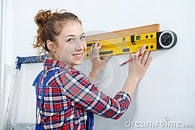 Young smiling woman using spirit level Stock Photo