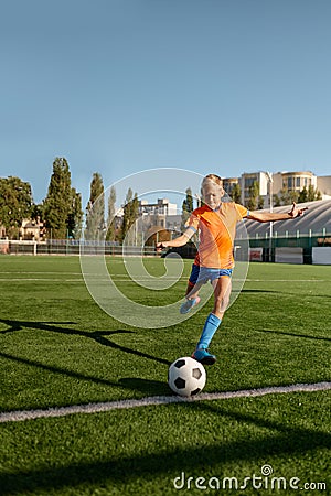 Young soccer goalie starting game kicking ball from white goal line Stock Photo