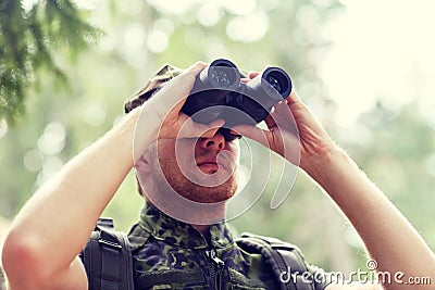 Young soldier or hunter with binocular in forest Stock Photo