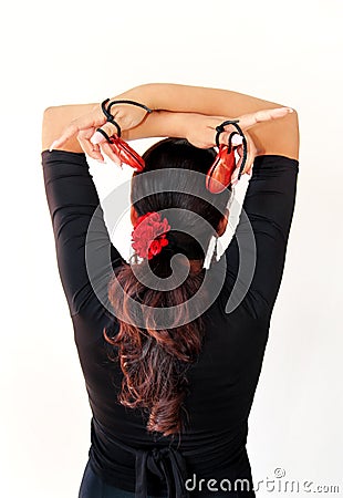 Young Spanish gipsy woman dancing flamenco with brown castanets. Stock Photo