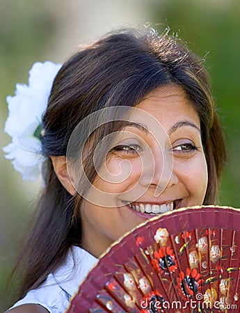 Young Spanish girl or woman smiling at camera holding traditional fan Stock Photo