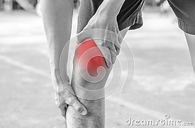 Young sport man with strong athletic legs holding knee Stock Photo