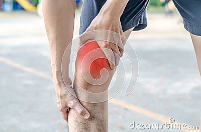 Young sport man with strong athletic legs holding knee with his Stock Photo