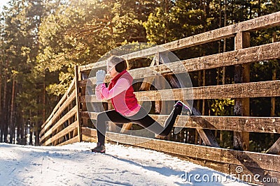 Young sport woman doing exercises during winter training outside. Stock Photo