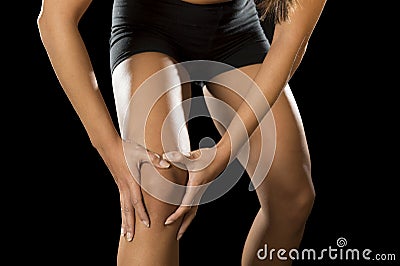 Young sport woman holding injured knee suffering pain in ligaments injury or pulled muscle Stock Photo