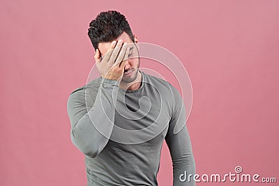 Young sports guy presses his palm to face as a sign of shame, failure, and headache. Negative emotions,mood and motivation. Stock Photo