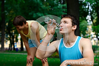 Young sportsman drinking water at the park Stock Photo