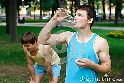 Young sportsman drinking water at the park Stock Photo