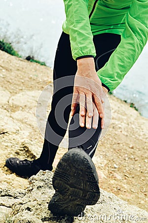 Young sportsman stretching his legs Stock Photo
