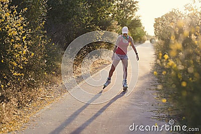 Young sportswoman having fun while roller skating outdoors Stock Photo