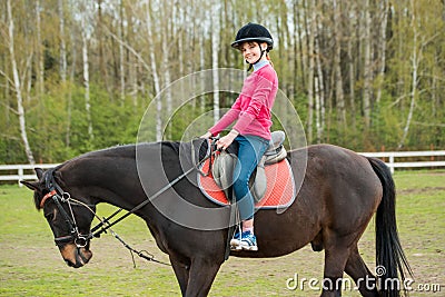 Young sportswoman riding horse in equestrian show jumps competition. Teenage girl ride a horse Stock Photo