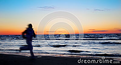 Young sportswoman running on the beach Stock Photo
