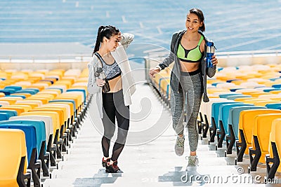 Young sportswomen with sport bottles on stadium stairs Stock Photo