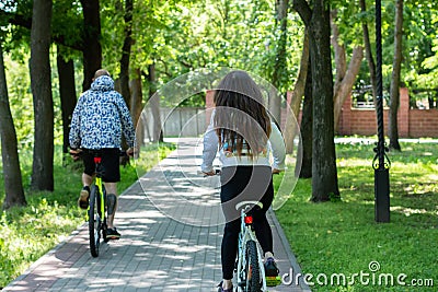 Young sporty couple riding on mountain bicycle on the road. Back view Editorial Stock Photo