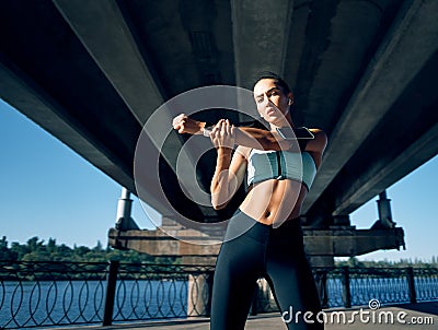 Young sporty female workout before fitness training session outdoors Stock Photo