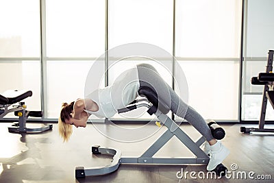 Young sporty woman in gym. Hyperextension exercise. Stock Photo