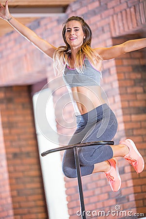 Young sporty woman jumping on mini trampoline in gym Stock Photo