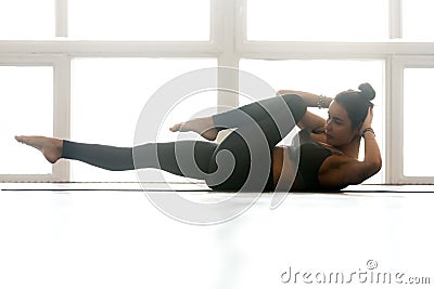 Young sporty woman practicing, doing crisscross exercise Stock Photo