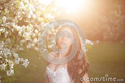 Young spring fashion woman in spring garden Springtime Summertime Trendy girl in the flowering trees in the spring summer garden Stock Photo