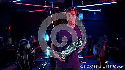 A young streamer talks about the advantages of the new gaming keyboard to his subscribers, holds the keyboard in his Stock Photo