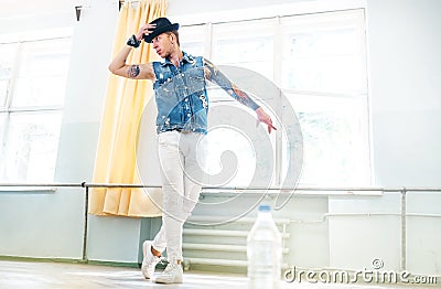 Young Street dancer dressed in jeans waistcoat and hat training Stock Photo