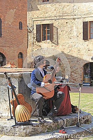 Young street musician playing on the square of the ancient city of San Gimignano Editorial Stock Photo