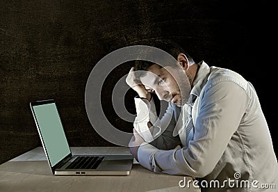 Young stressed businessman working on desk with computer laptop in frustration and depression Stock Photo