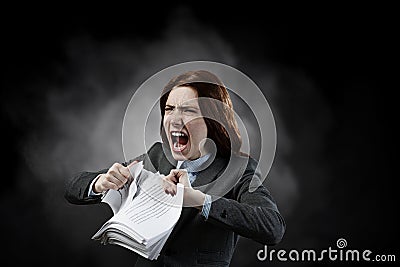 Young stressed woman ripping documents with frustrated facial expression. Stock Photo