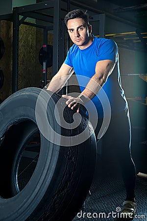 Young strong athlete posing with a heavy wheel Stock Photo