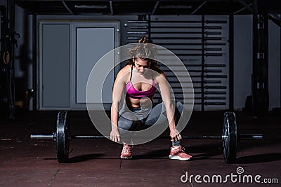 Young strong muscular fit girl with big muscles preparing for hard strength weightlifing or dead lift cross workout training with Stock Photo