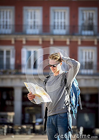 Young student backpacker tourist looking city map lost and confused in travel destination Stock Photo