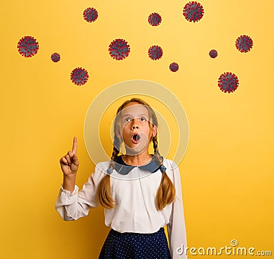 Young student is with shocked expression and indicates codiv-19 virus. Yellow background Stock Photo