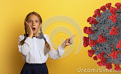 Young student is with shocked expression and indicates covid-19 bacteria. Yellow background. Stock Photo