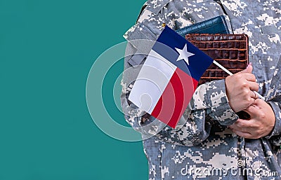 Young student soldier in uniform with books holds in hand Texas flag, close up Stock Photo