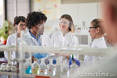 Young students discussing about the experiment in the laboratory. Science, chemicals, lab, people Stock Photo