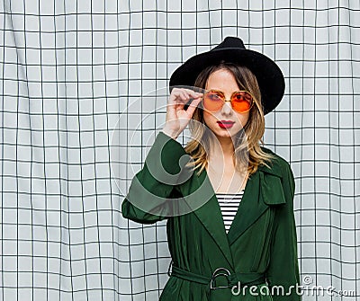 Young style woman in sunglasses and green cloak in 90s style Stock Photo